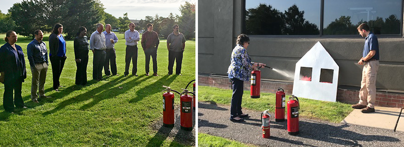 Office employees practicing use of fire extinguisher outdoors.